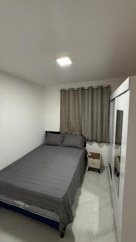 a bedroom with a large bed and a window at Casa nova e aconchegante em condomínio in Petrolina