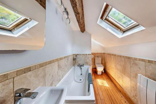 a bathroom with a tub and a sink and skylights at The Mountains House in Blaenau-Ffestiniog