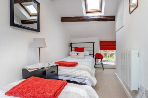 a bedroom with two beds with red pillows at Ty Isa Llanuwchllyn in Llanuwchllyn