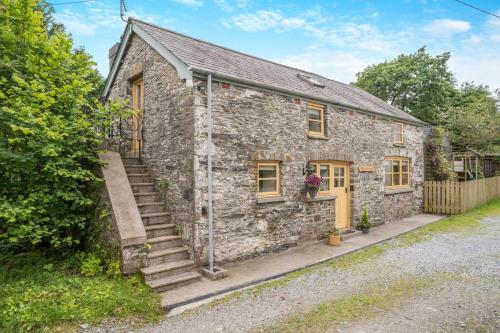 an old stone house with stairs in front of it at The Old Cart House - Crugybar in Rhandirmwyn