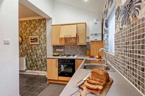 a kitchen with a sink and a loaf of bread on a counter at Redcote in Old Colwyn