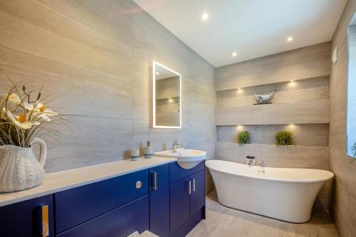 a bathroom with two sinks and a large tub and a sink at Bryn Deufor in Aberdaron