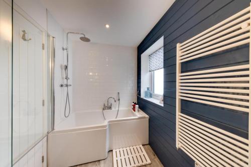 a bathroom with a tub and a sink and a window at Ty Mor Wennol in Aberdyfi