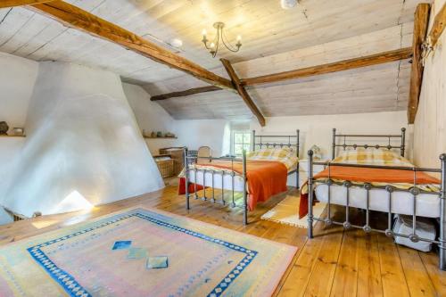 2 Betten in einem großen Zimmer mit Holzdecken in der Unterkunft Tanybryn Cottage in Llangeitho