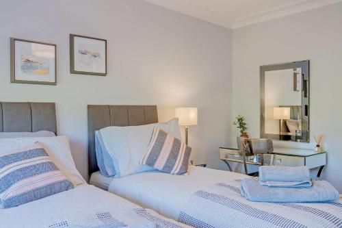 a bedroom with two beds and a mirror at Ty Eithin in Gwbert