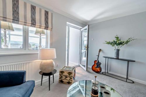 a living room with a glass table and a guitar at Ty Eithin in Gwbert