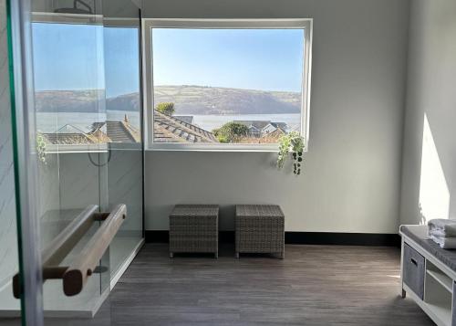 a bathroom with a bench and a large window at Ty Eithin in Gwbert