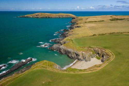 an aerial view of a golf course next to the ocean at Ty Eithin in Gwbert