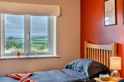 a bedroom with a bed and a window at Little Hill End Stables - Reynoldston in Reynoldston