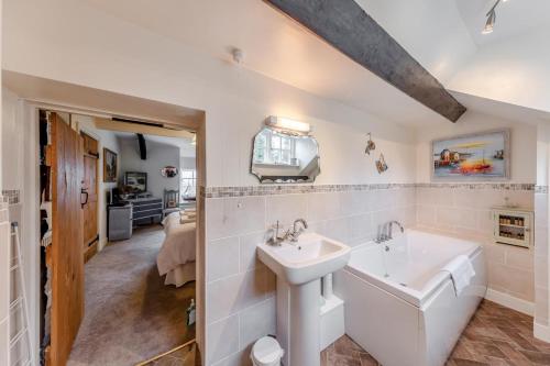a white bathroom with a sink and a tub at Bron LLety Ifan in Arthog