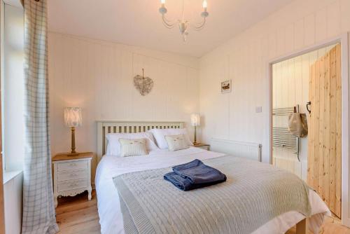 a bedroom with a bed with a blue bag on it at Eryl in Ferryside