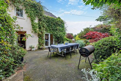 a table and chairs and a grill in a garden at Cryngae in Felindre