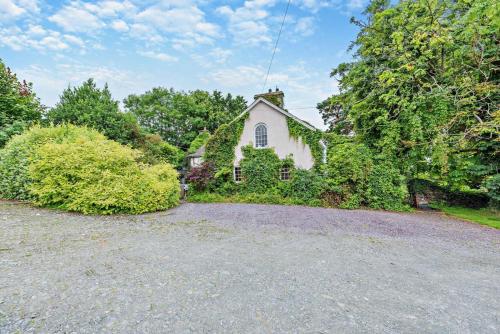 an old white house with trees and bushes at Cryngae in Felindre