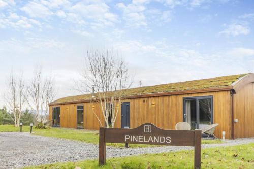 a sign in front of a wooden building at Pinelands at Bryn Tanat in Llanymynech