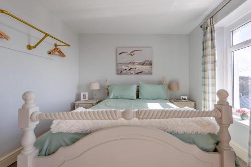 una camera da letto con un letto e una finestra di Ocean View Cottage - Burry Port a Burry Port