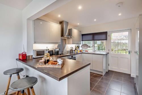 a kitchen with white cabinets and a counter top at Nyth yr Wylan in Aberdyfi