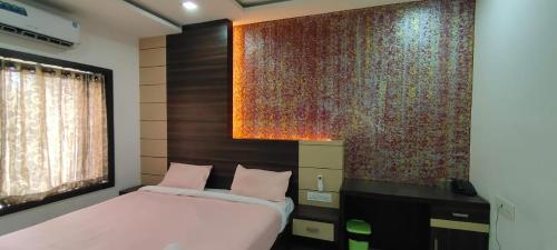 a bedroom with a bed and a large wall at HOTEL AL AMANA TOWER in Kondotti