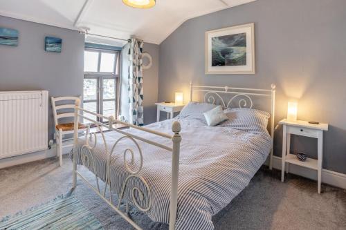 a bedroom with a white bed and a window at Lavender Cottage - Mumbles in The Mumbles