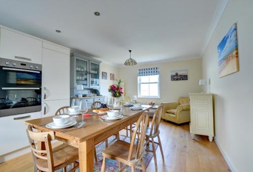 a kitchen and dining room with a wooden table and chairs at Cockleshell in Amroth