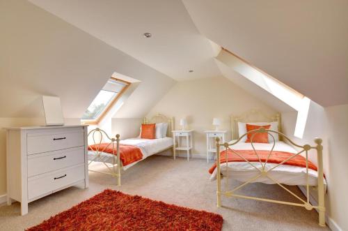 a attic bedroom with two beds and a window at Cockleshell in Amroth