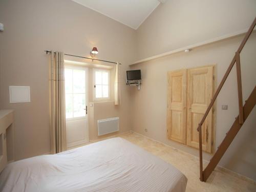 a bedroom with a bed and a staircase with a window at Villa in Provence with Infinity Pool in Martres-Tolosane