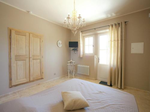 a bedroom with a large bed and a chandelier at Villa in Provence with Infinity Pool in Martres-Tolosane