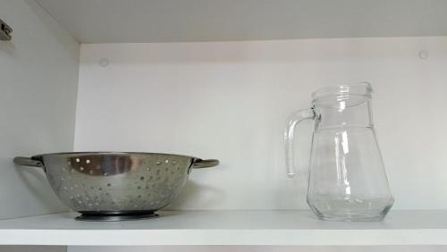 a mixing bowl and a glass jug on a shelf at 8º Relax - Cama de Massagem! in Uberlândia