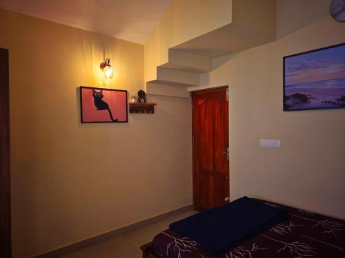 a room with a bed and a picture of a cat on the wall at Tranquil Nest Villa - 4BHK Villa - Entire Villa stay in Wayanad in Kalpetta