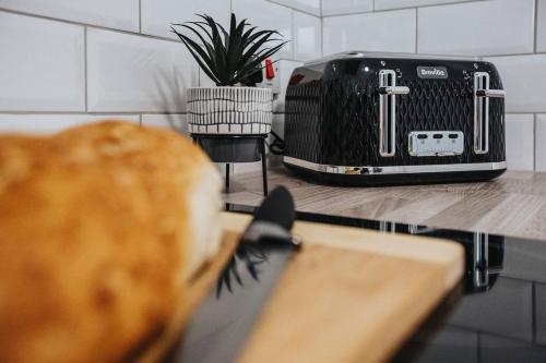 a toaster sitting on top of a counter next to a table at Curlew Stays - Semi Detached Home - Pet Friendly in Thornton