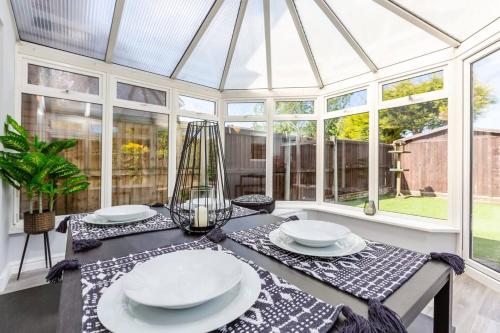 a glass conservatory with a table with plates on it at Curlew Stays - Semi Detached Home - Pet Friendly in Thornton