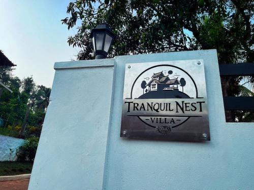 a sign for a mansion nest villa on a wall at Tranquil Nest Villa - 4BHK Villa - Entire Villa stay in Wayanad in Kalpetta