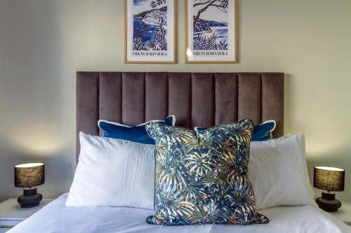 a bed with a headboard with pillows and two lamps at AlimamaSpaces Phillys Whisken in Midrand