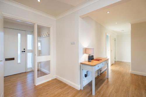 ein weißer Raum mit einem Schreibtisch und einem Spiegel in der Unterkunft Balass Lodge near The Old Course St Andrews in Fife