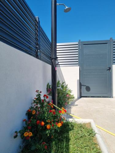 een hek met bloemen naast een gebouw met een deur bij Bazen na dan Saray pool in Mostar