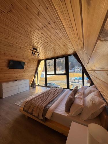 a large bed in a room with a large window at Cabana A Vaideeni in Vaideeni