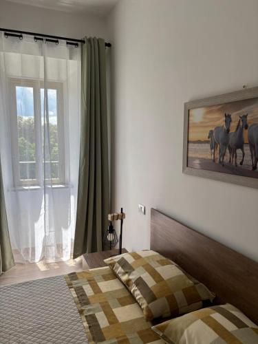 a bedroom with a bed with a picture of horses on the wall at Domus Anfiteatro Home Sweet Home Viterbo in Sutri