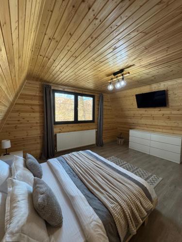 a bedroom with a large bed in a wooden room at Cabana A Vaideeni in Vaideeni