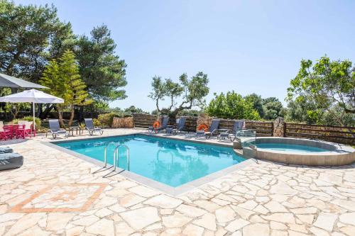 a swimming pool with chairs and a table at Villa Ariadne Aresti in Agios Leon