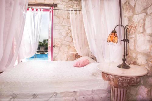 a bedroom with a bed with a table and a window at Villa Ariadne Aresti in Agios Leon