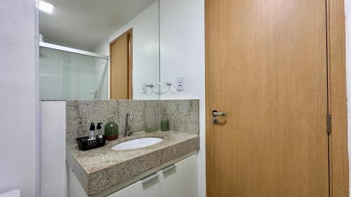 une salle de bain avec un lavabo et un miroir dans l'établissement AP822 ar condicionado piscina academia coworking etc, à Juiz de Fora