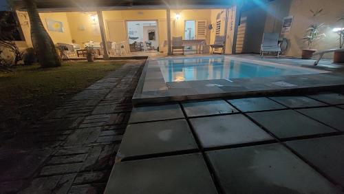 a swimming pool in a backyard at night at Villla NOULAKAZ in Port Mathurin