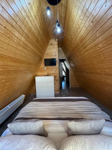 a large bed in a room with a wooden ceiling at Cabana A Vaideeni in Vaideeni