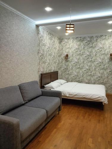 a living room with a couch and a bed at Апартаменти ЖК Покровський двір Чабани in Chabany