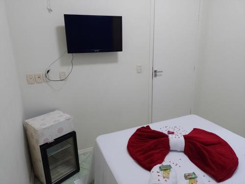 a bow tie sitting on a bed with a tv at Residencial Refugio do Mar in Florianópolis