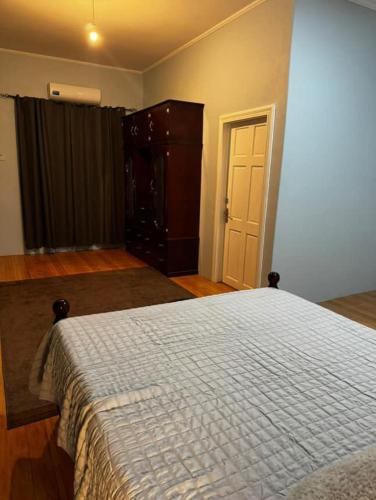 a bedroom with a bed and a dresser and a door at Modern and Stylish Apartment in Courida Park