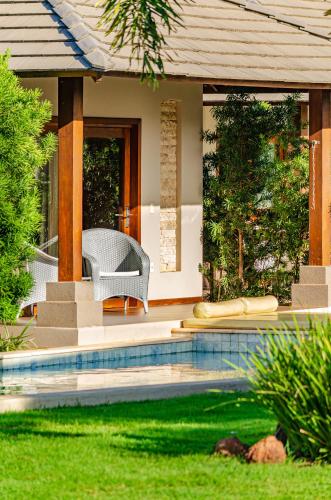 a house with a swimming pool in the yard at AWARA POUSADA BOUTIQUE in São Miguel do Gostoso