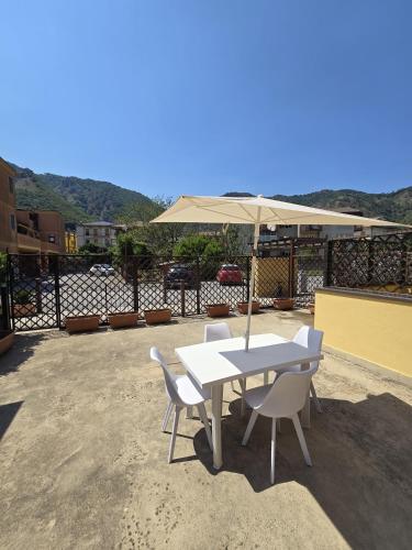 a white table and chairs with an umbrella at Diecimare in Baronissi