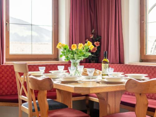 a wooden table with a vase of flowers on it at Almruhe Alpbach in Alpbach