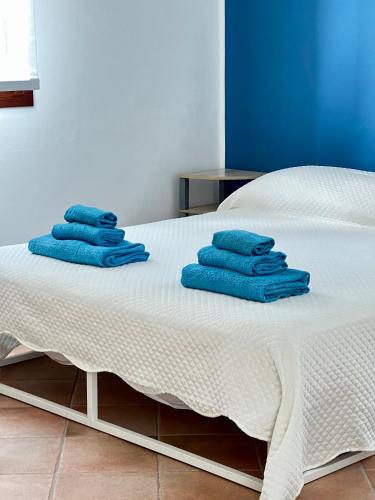a bed with blue towels on top of it at Villa Oasi Mariuccia - Relax e Mare in Lido di Jesolo