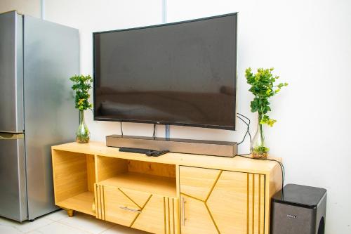 a flat screen tv sitting on a wooden entertainment center at Myla homes in Kiambu